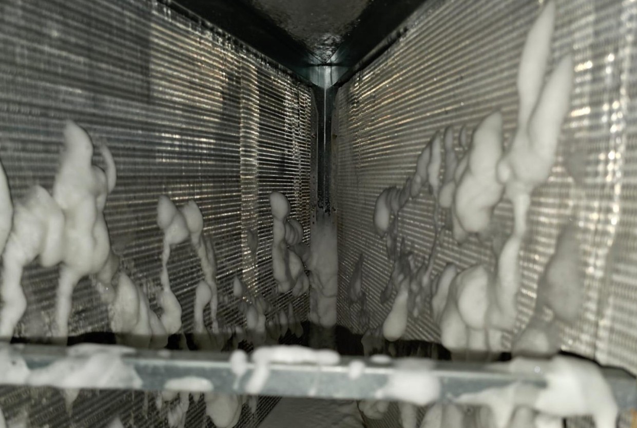 Foaming HVAC coil cleaner working through the indoor coil fins during preventive maintenance
